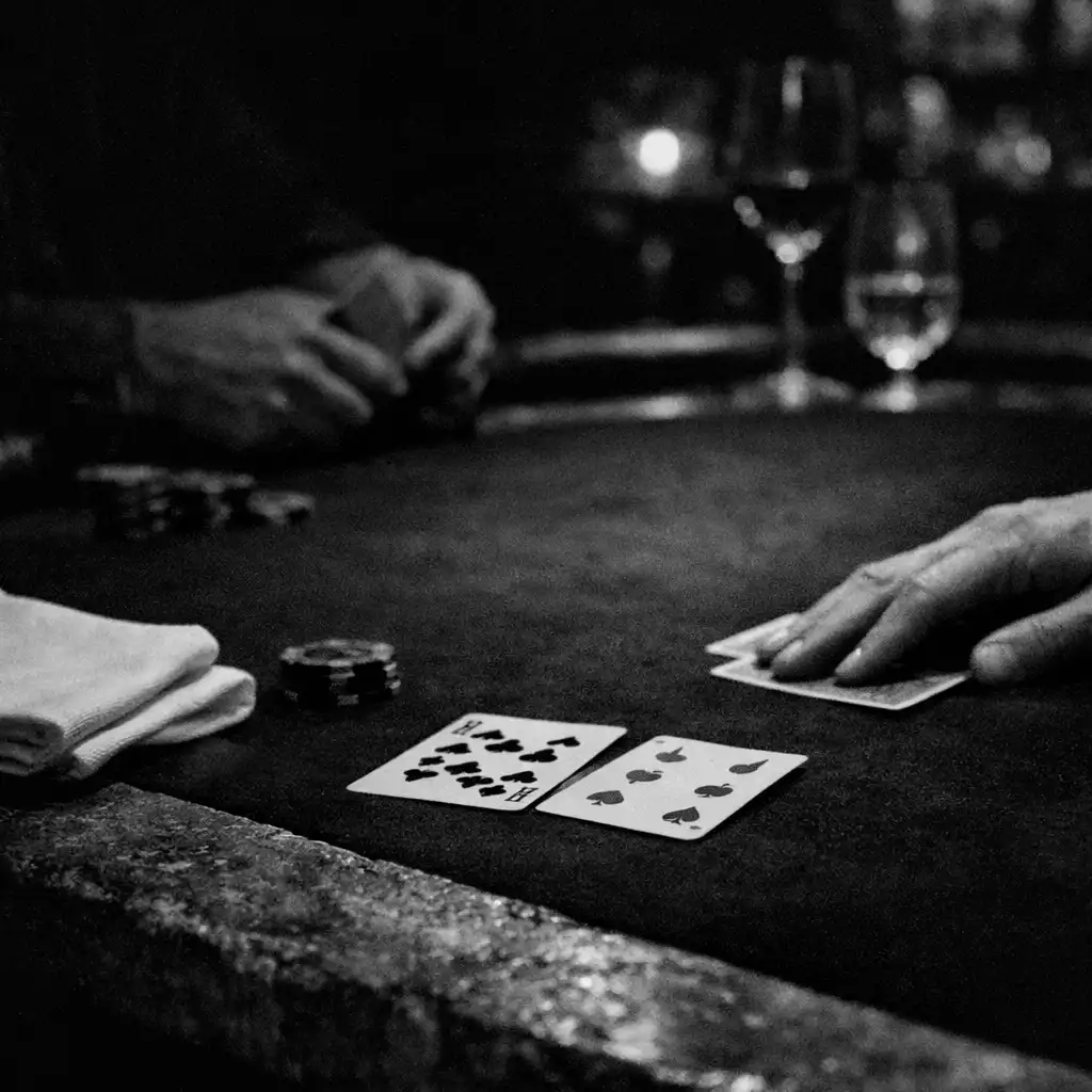 Hands, linen and physical cards on a dark felt poker table inside the Card Lounge