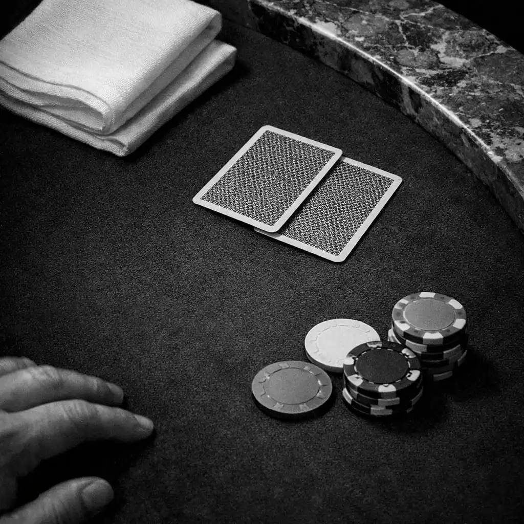 Dark felt, linen, cards and a marble boundary at a physical poker table